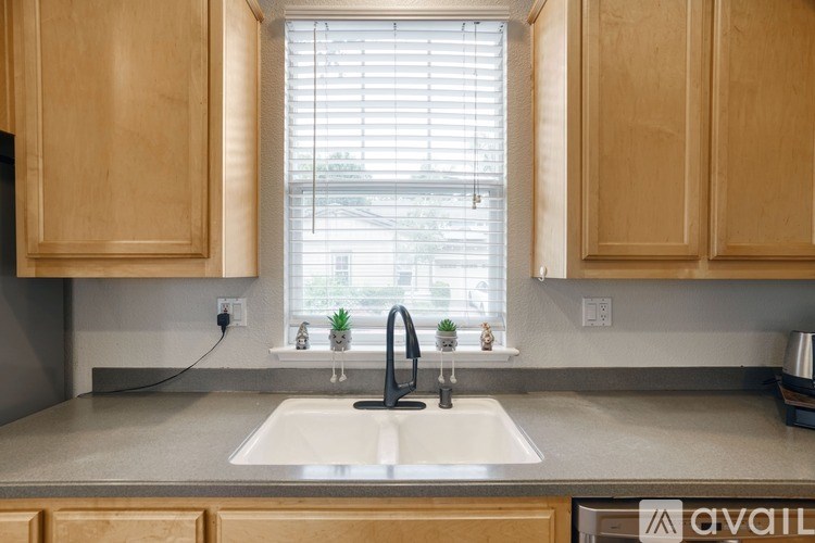 A kitchen with wooden cabinets and a white sink.