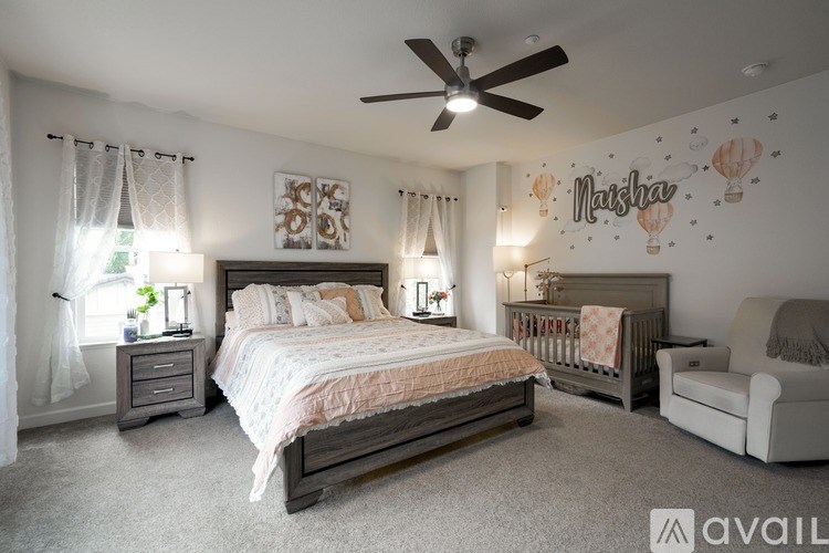 A bedroom with a bed, a couch, and a ceiling fan.