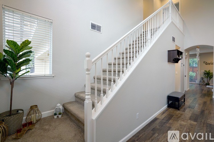 A living room with a staircase and a television.