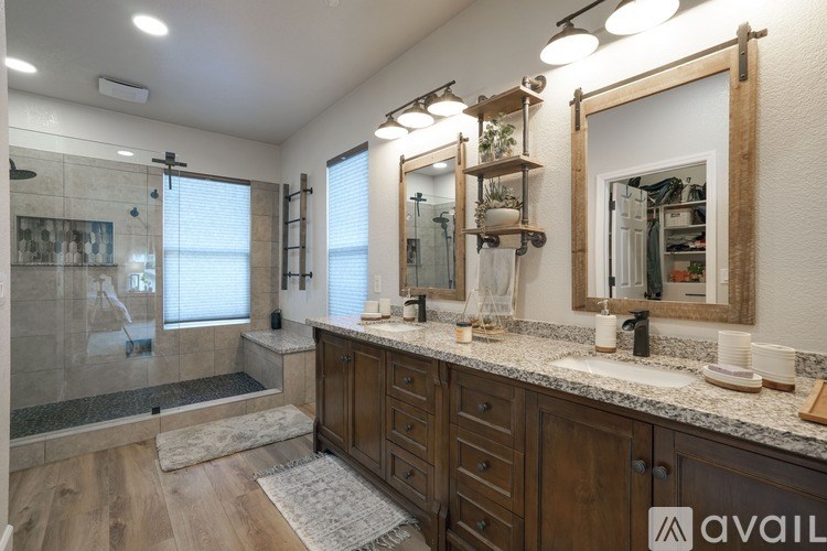A bathroom with a walk-in shower and double sinks.
