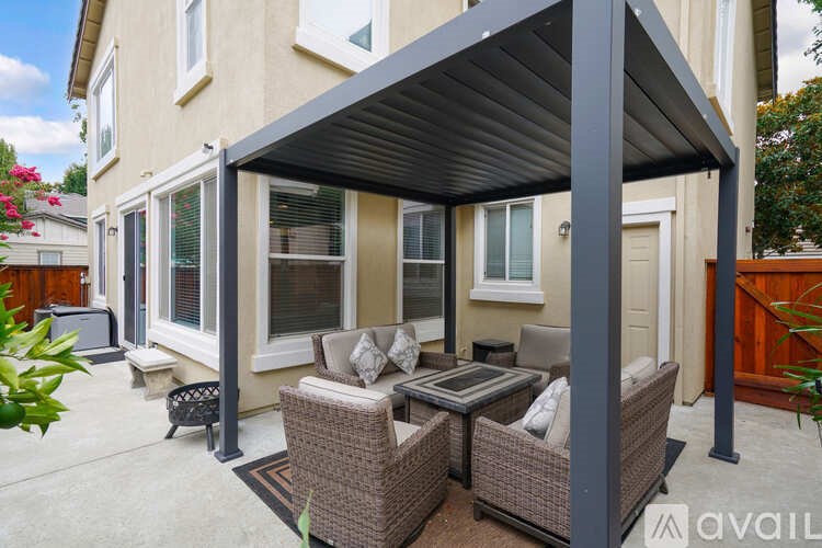 A patio with a table and chairs under a roof.