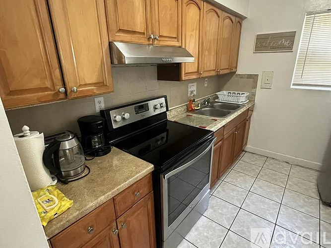 A kitchen with wooden cabinets and a black stove top oven.