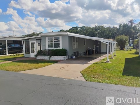 A house with a carport and a driveway in front.