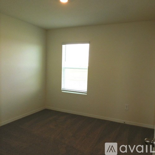 A room with a window and wooden flooring.