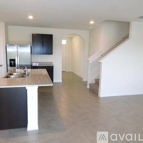A kitchen with a sink and a refrigerator.