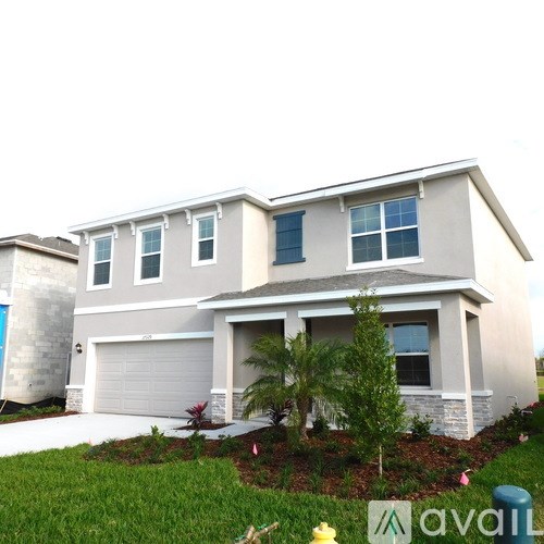 A two-story house with a garage and a driveway.