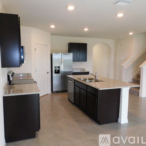 A kitchen with black cabinets and a white countertop.