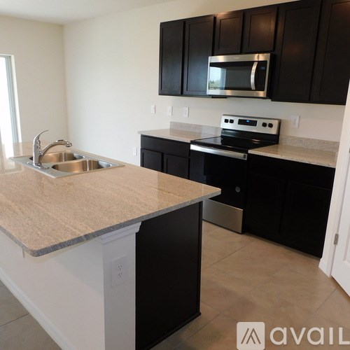 A kitchen with black cabinets and a beige countertop.