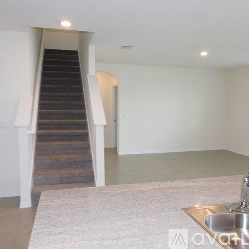A staircase with a carpeted floor and a sink in the foreground.