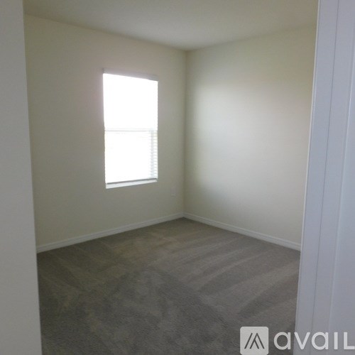 A room with a window and carpeted floor.