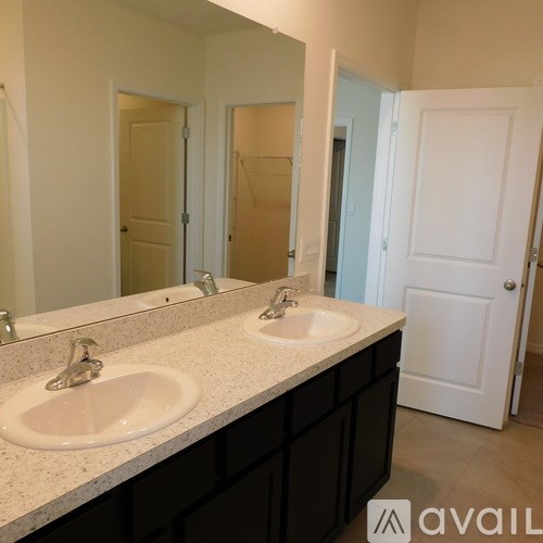 A bathroom with two sinks and a large mirror.