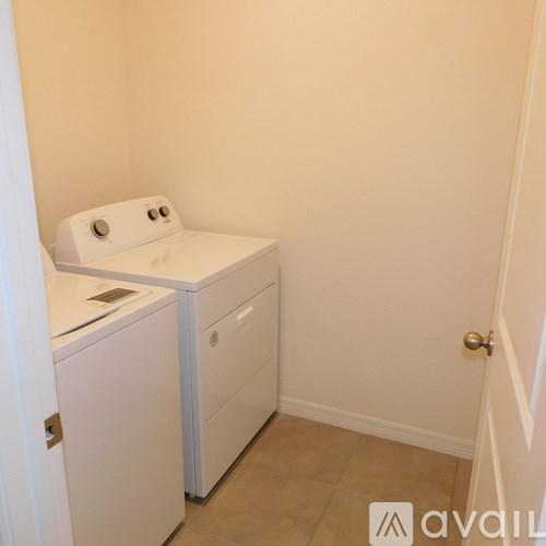 A white washing machine and dryer in a small laundry room.