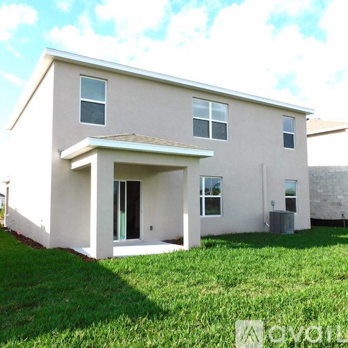 A beige house with a brown roof and a white door.