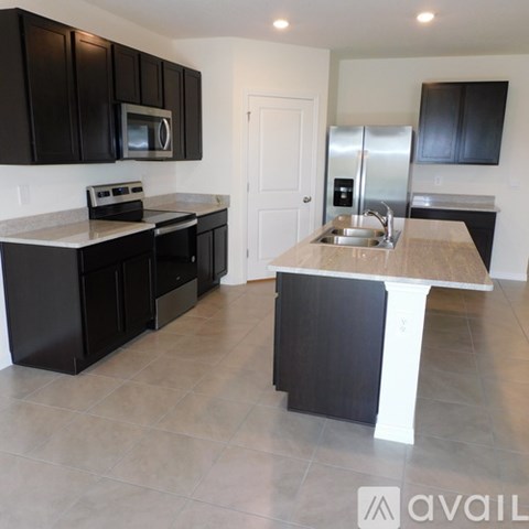 A kitchen with black cabinets and a white island.