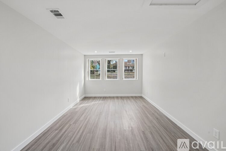 A room with a white wall and wooden floor.