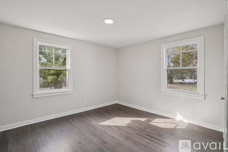 A room with a window and wooden flooring.