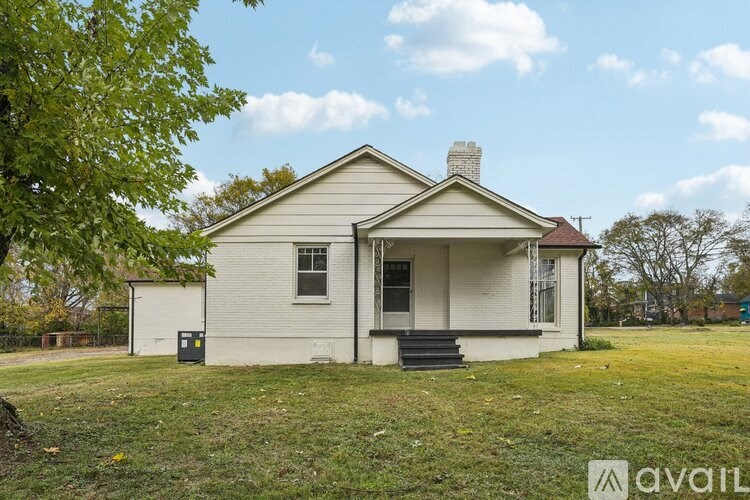 A white house with a black door and a brown roof.