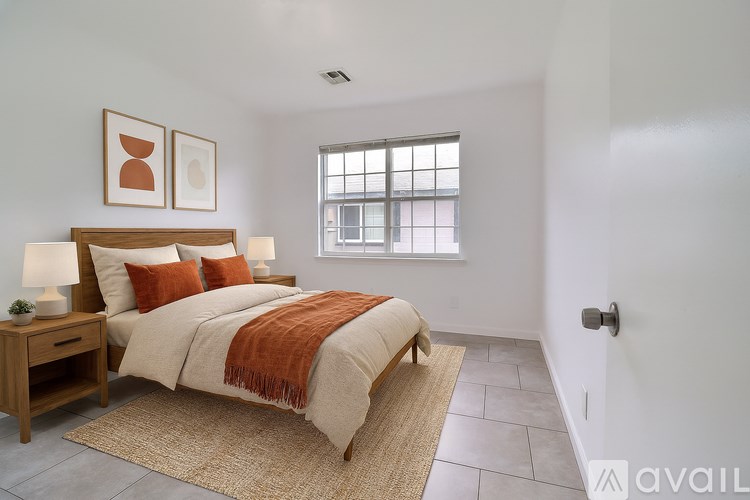 A bedroom with a bed, nightstand, and window.