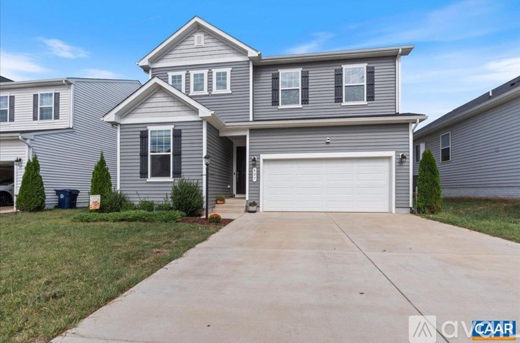 A grey house with a white garage door in front.