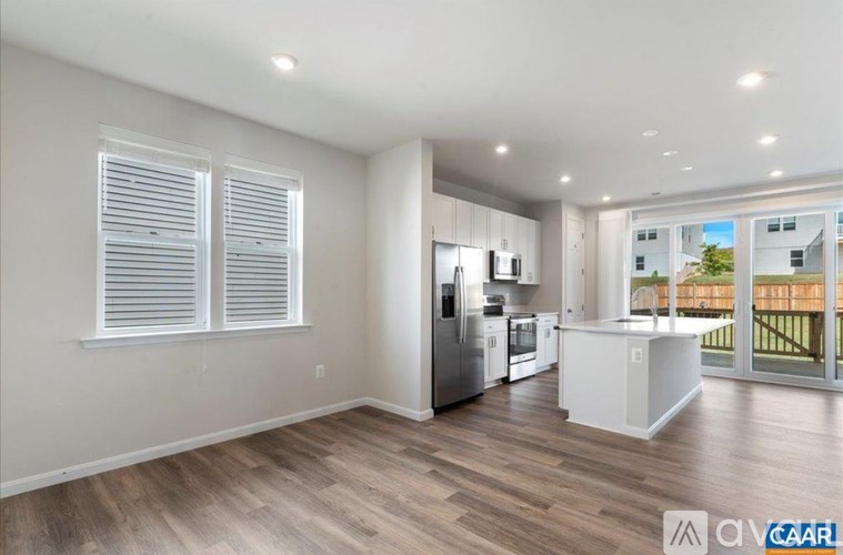 A spacious kitchen with white cabinets and a refrigerator.