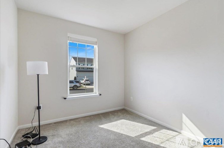 A room with a window showing an outdoor scene with a car and a house.