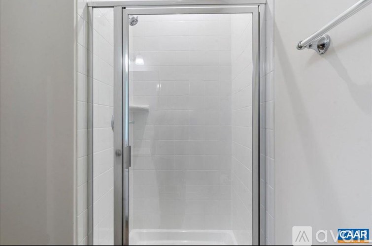 A glass door in a white tiled bathroom.