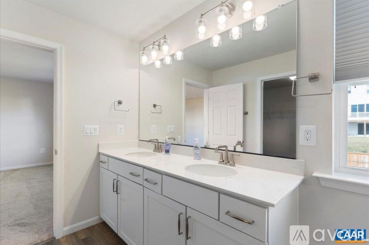 A bathroom with a vanity, sink, and mirror.