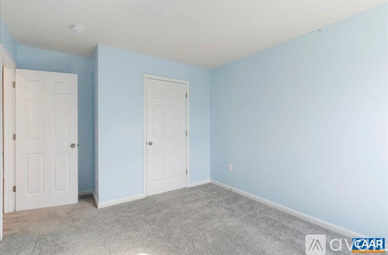 A room with two doors and carpeted floor.