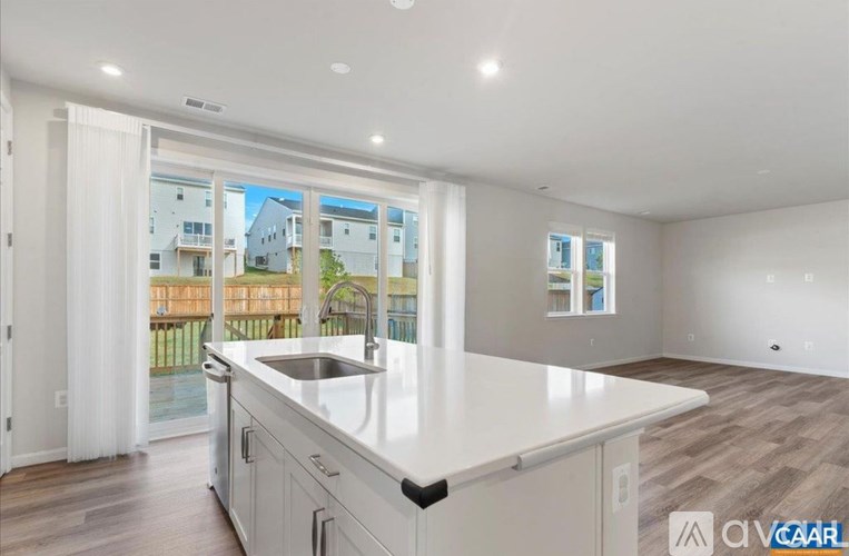 A modern kitchen with white cabinets and a large island.