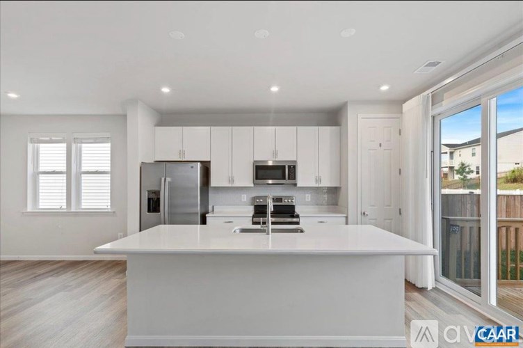 A modern kitchen with white cabinets and appliances.
