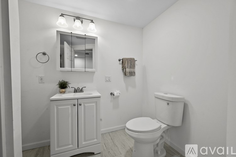 A white bathroom with a toilet, sink, and medicine cabinet.