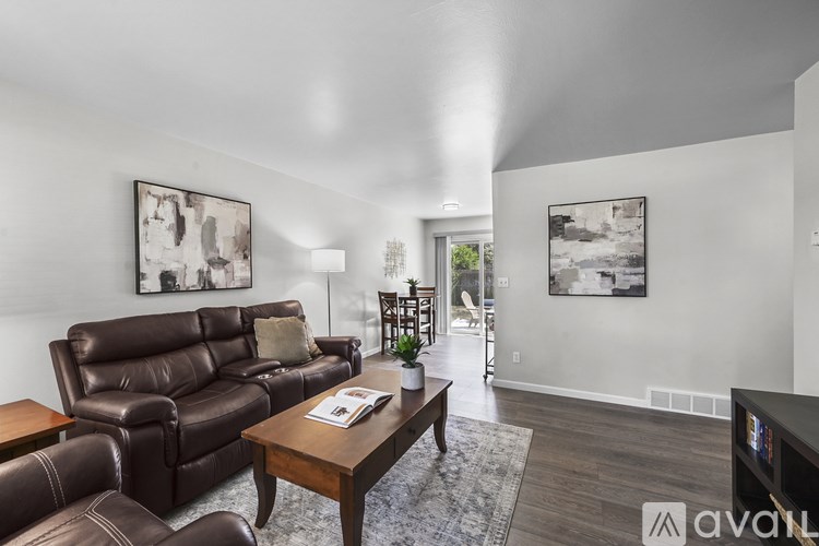 A living room with a brown leather couch and a wooden coffee table.