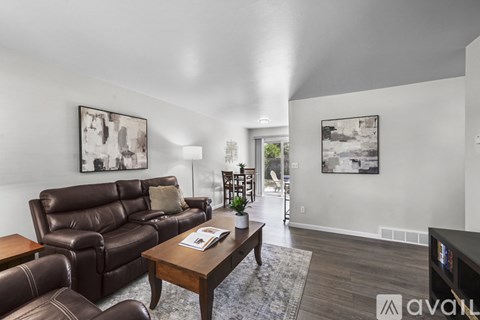 A living room with a brown leather couch and a wooden coffee table.