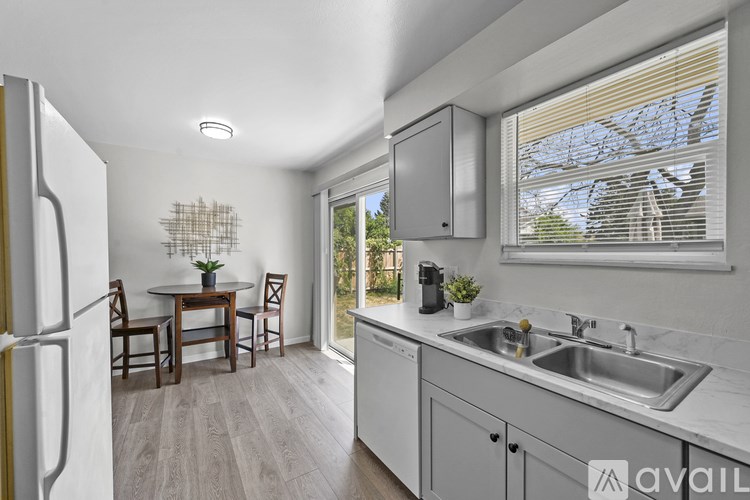 A kitchen with a table and chairs in front of a window.