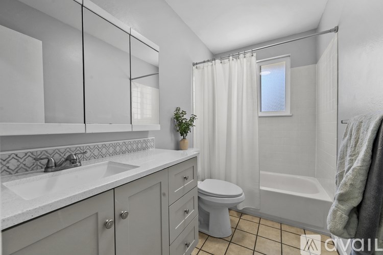 A bathroom with a toilet, sink, and bathtub.