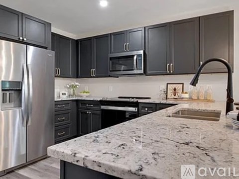 A kitchen with a marble countertop and stainless steel appliances.