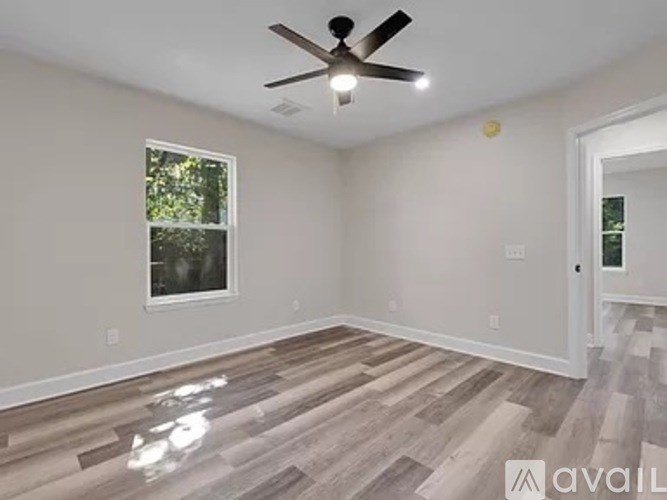 A room with a ceiling fan and a window.