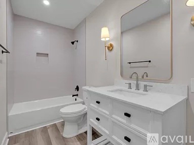 A white bathroom with a toilet, sink, and bathtub.