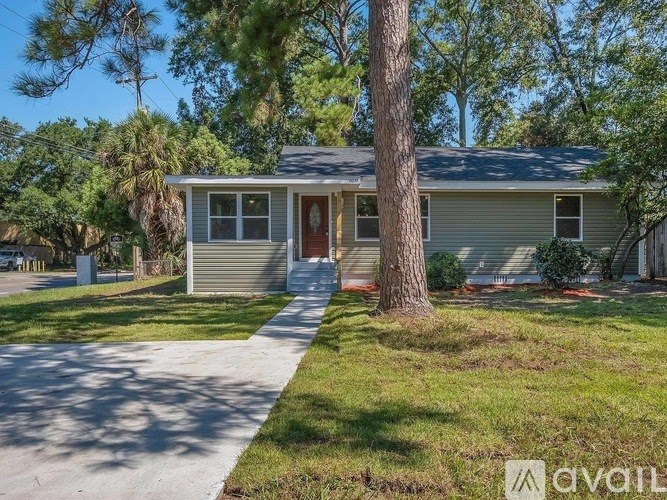 A house with a brown door is surrounded by greenery.
