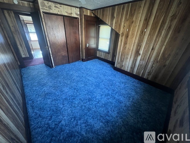 A room with wooden walls and a blue carpet.