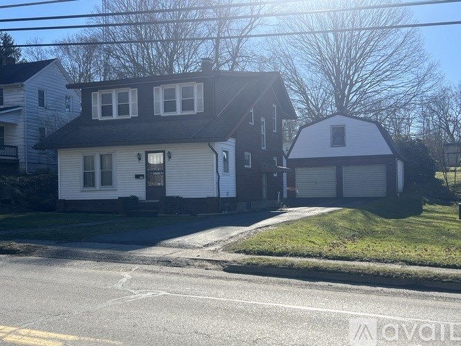 A house with a white garage door is situated on a street.