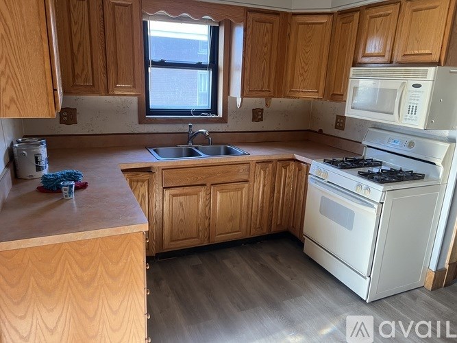 A kitchen with wooden cabinets and a white stove top oven.