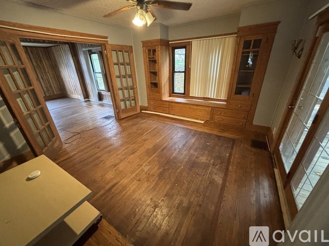 A room with wooden floors and a ceiling fan.