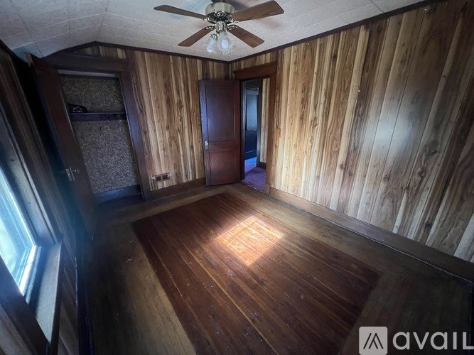A room with wooden walls and a ceiling fan.