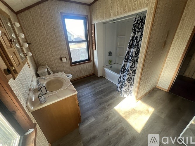 A bathroom with a sink, mirror, and shower.