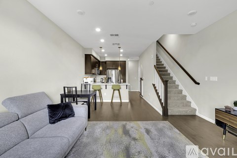 A living room with a grey couch and a rug in the foreground.
