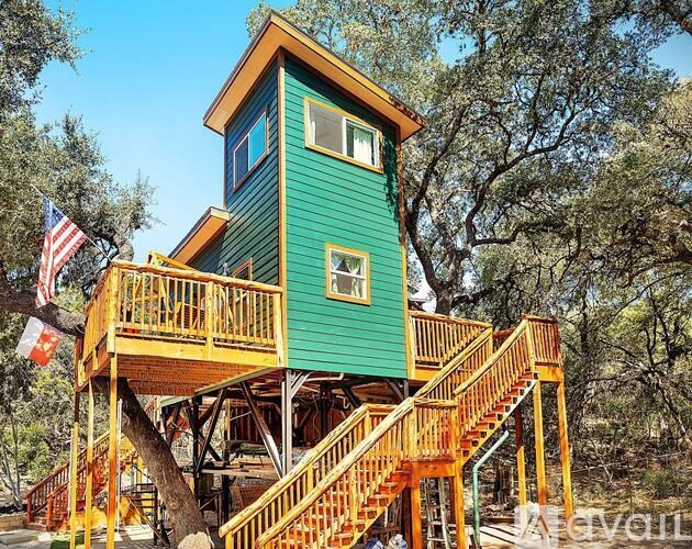 A treehouse with a green exterior and a balcony.