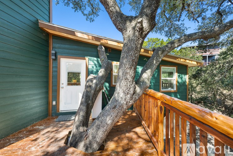 A tree trunk is growing out of a deck.