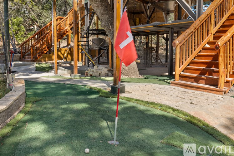 A red flag on a golf course with a green lawn.