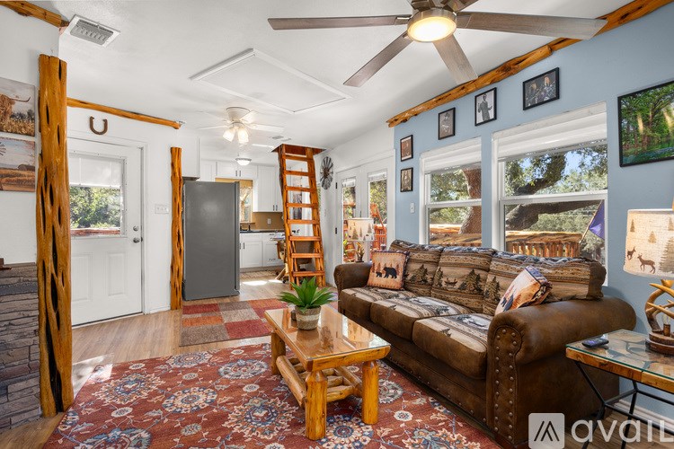A living room with a brown couch, a wooden coffee table, and a rug.